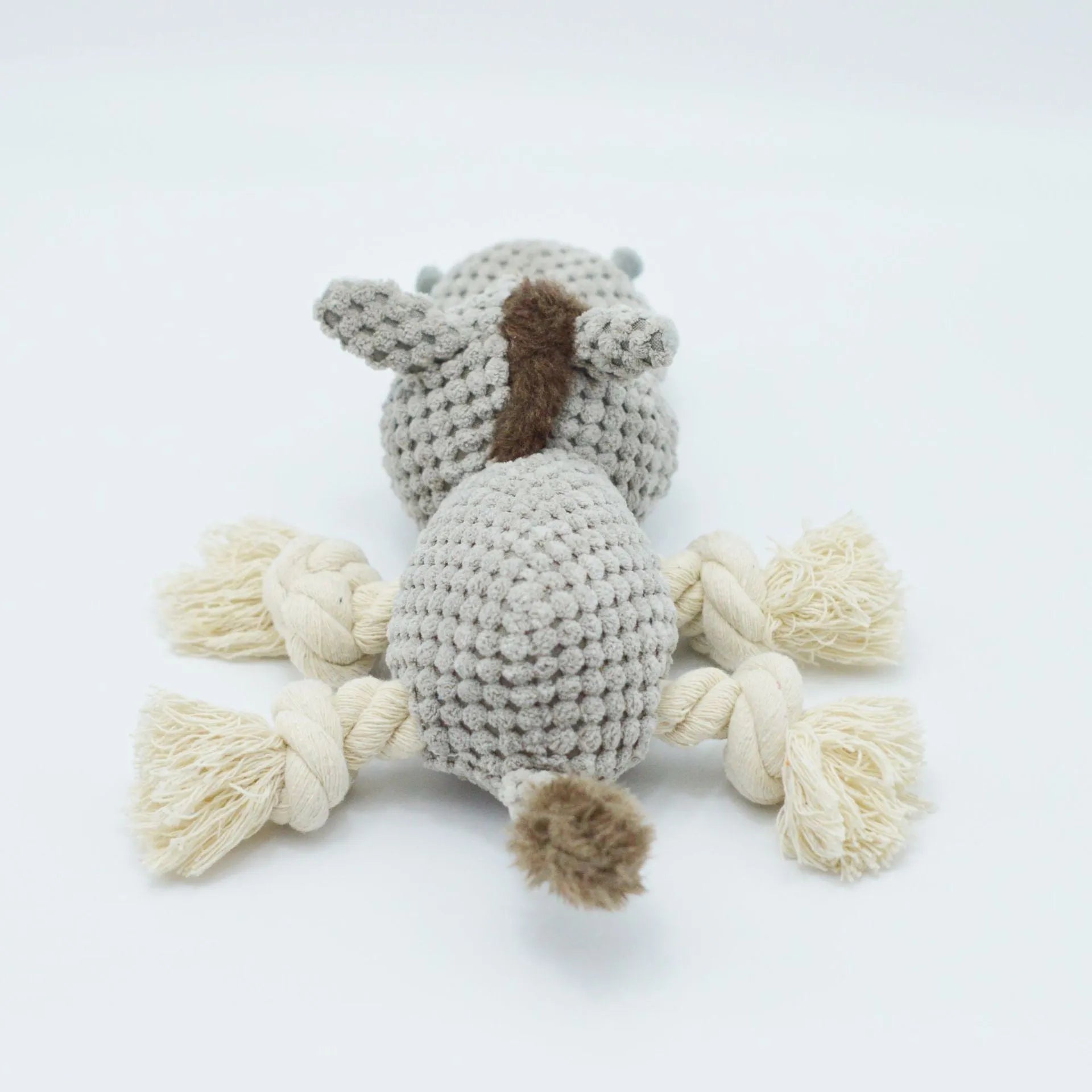 Grey plush donkey dog toy with creaking sound, showing size against a hand.