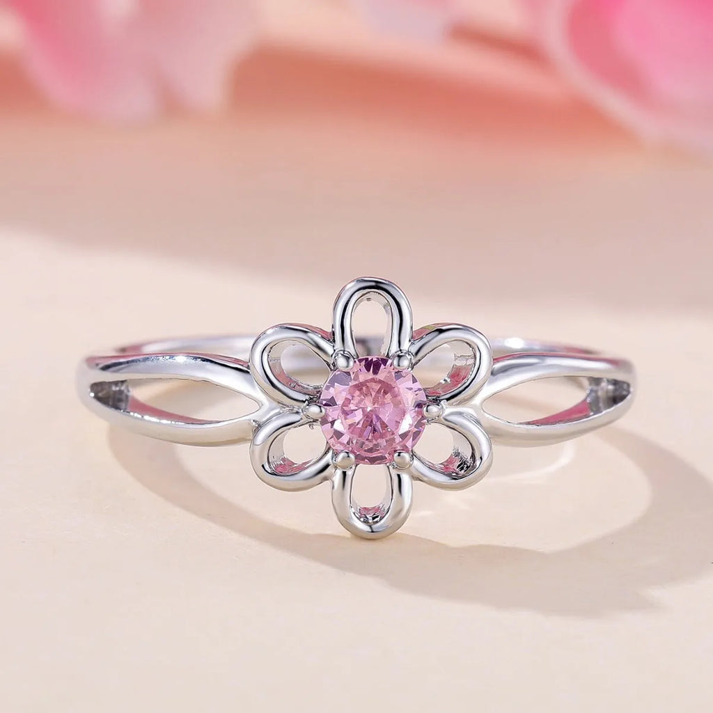 Women's hollowed flower fashion ring in electroplated platinum pink diamond colour on a white background.