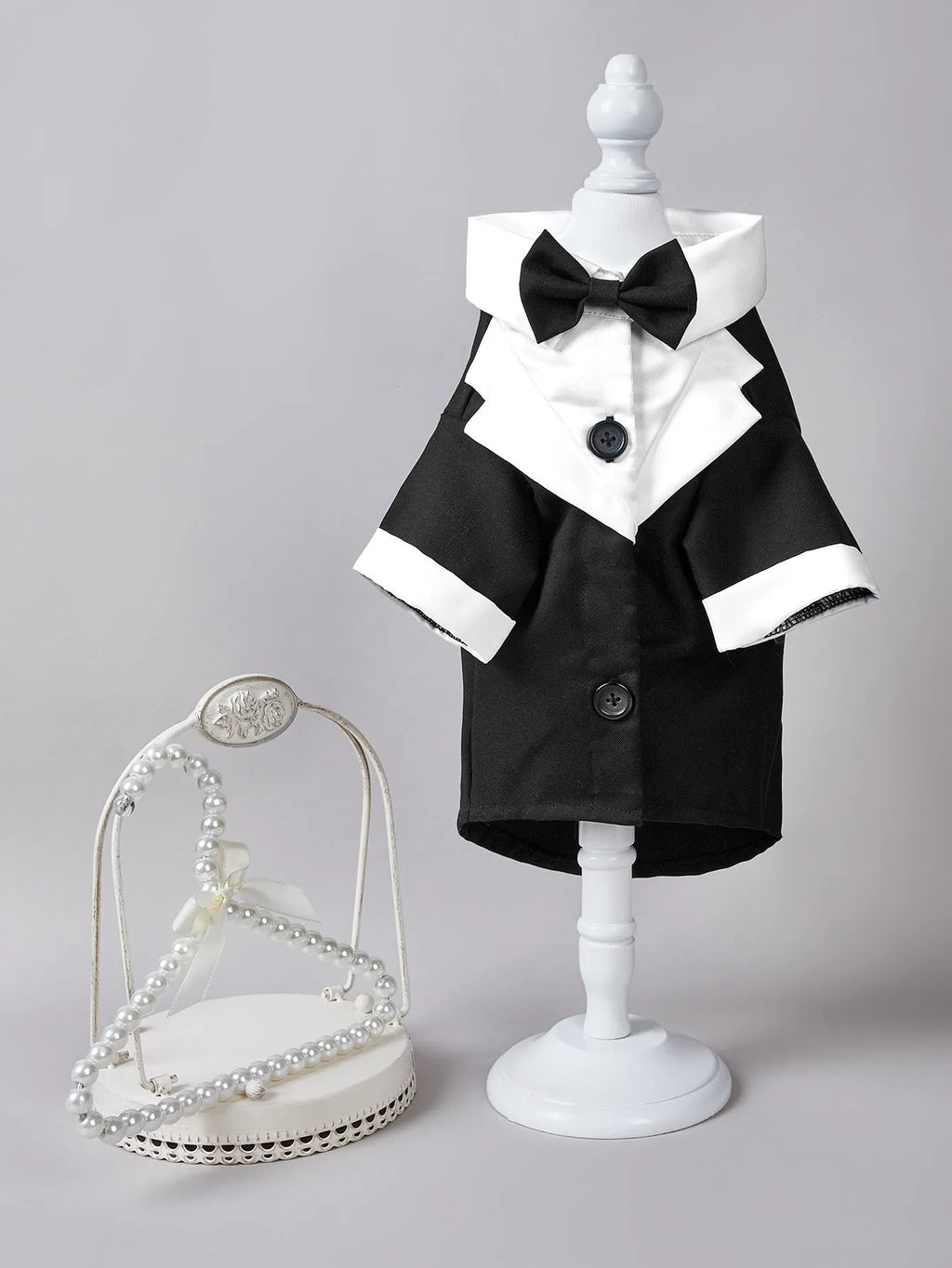 A dog wearing a black Chinese-style four-legged gentleman suit, a formal wedding tuxedo for pets.
