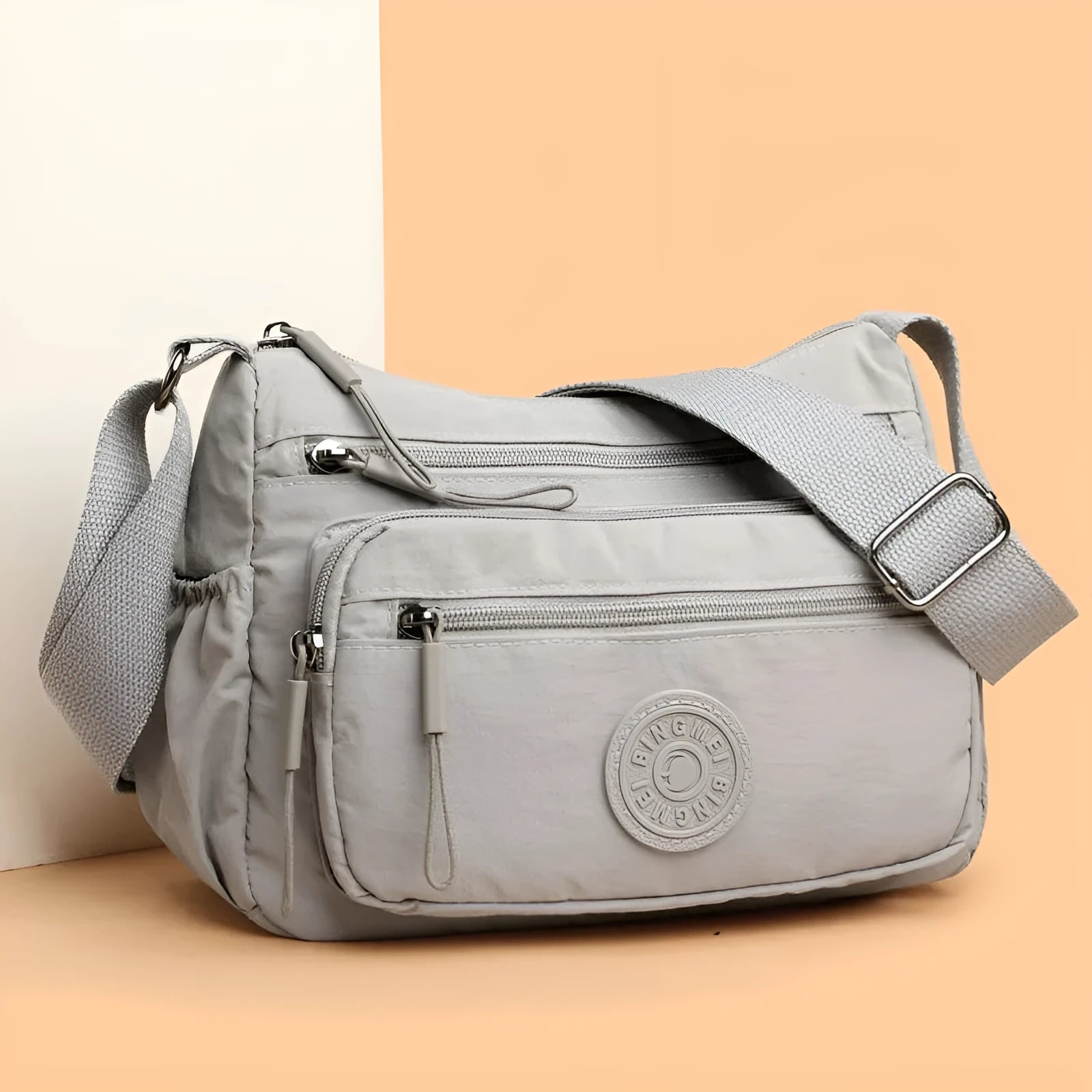 Grey water-repellent nylon crossbody bag showing outer pocket and internal organiser compartments.