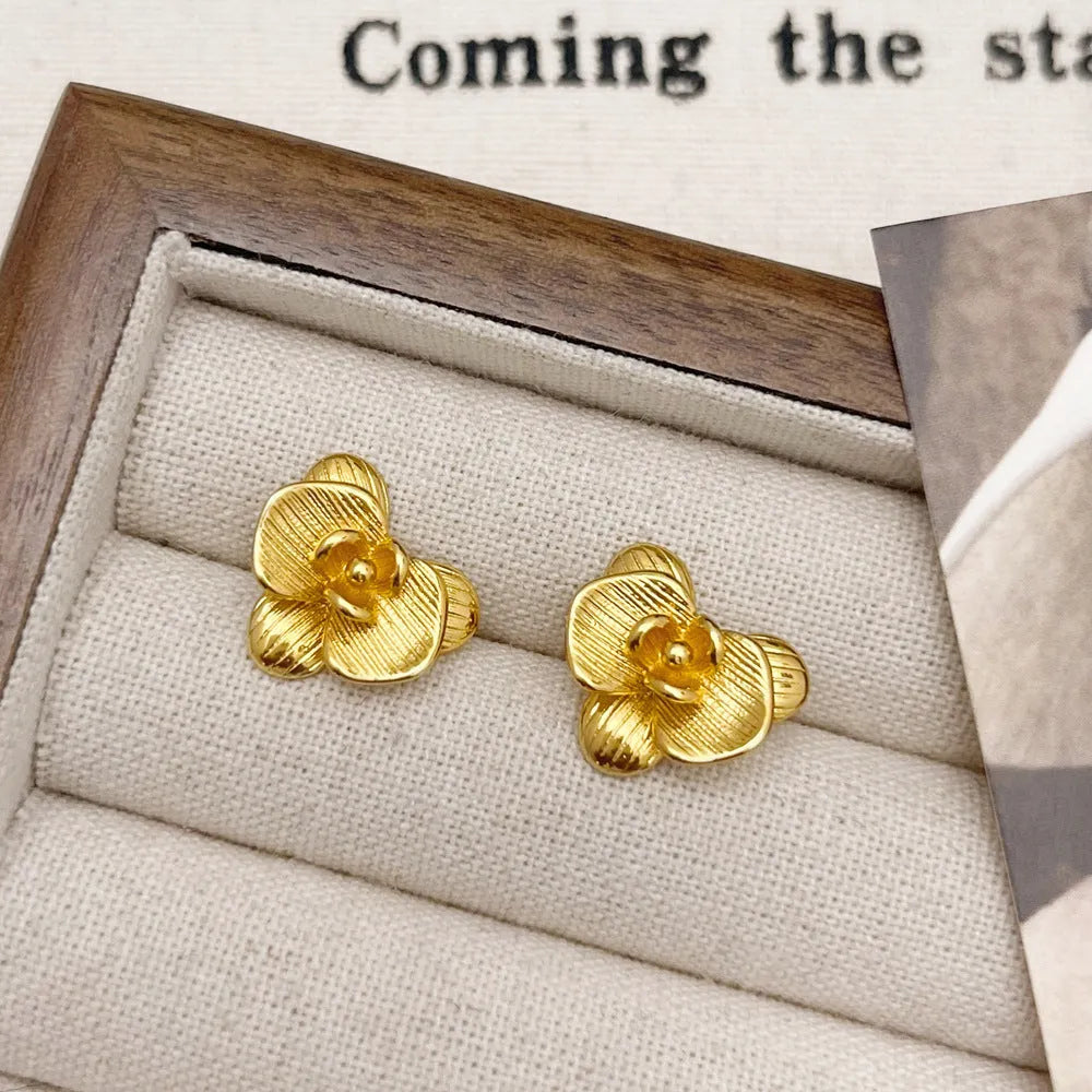 A pair of retro-style flower earrings with petal design, shown in gold electroplated finish.