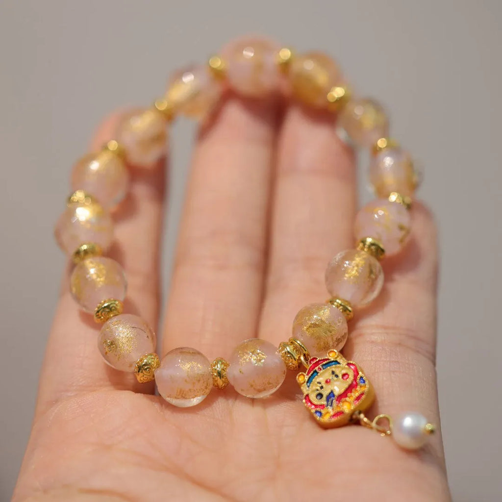 Women's handmade coloured glaze bracelet with gold foil decoration in geometric ethnic style design