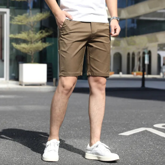 Man wearing loose-fit beige mid-length casual trousers with an elasticated waistband.