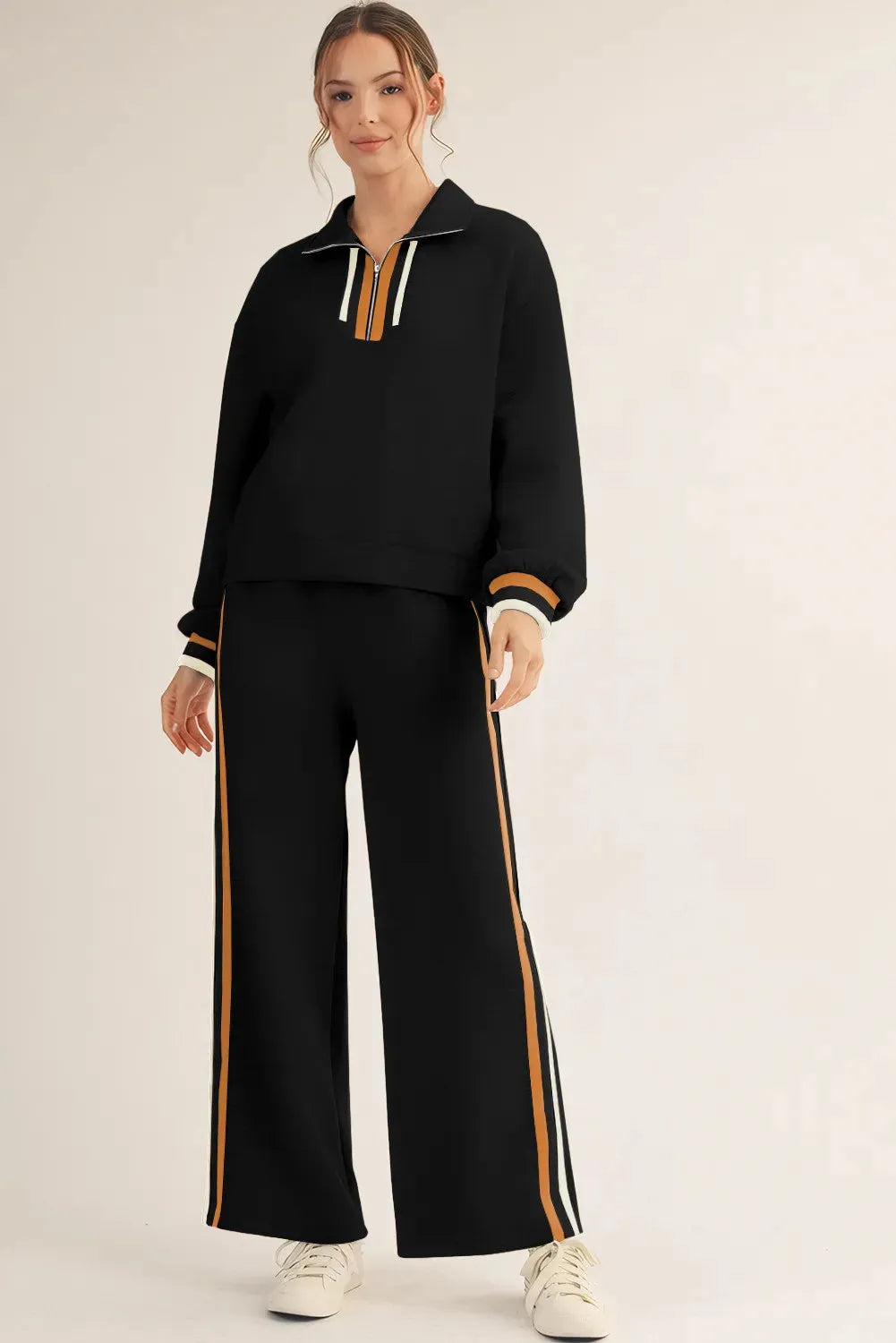 Black striped patchwork quarter zip pullover and loose pant set on a plain background