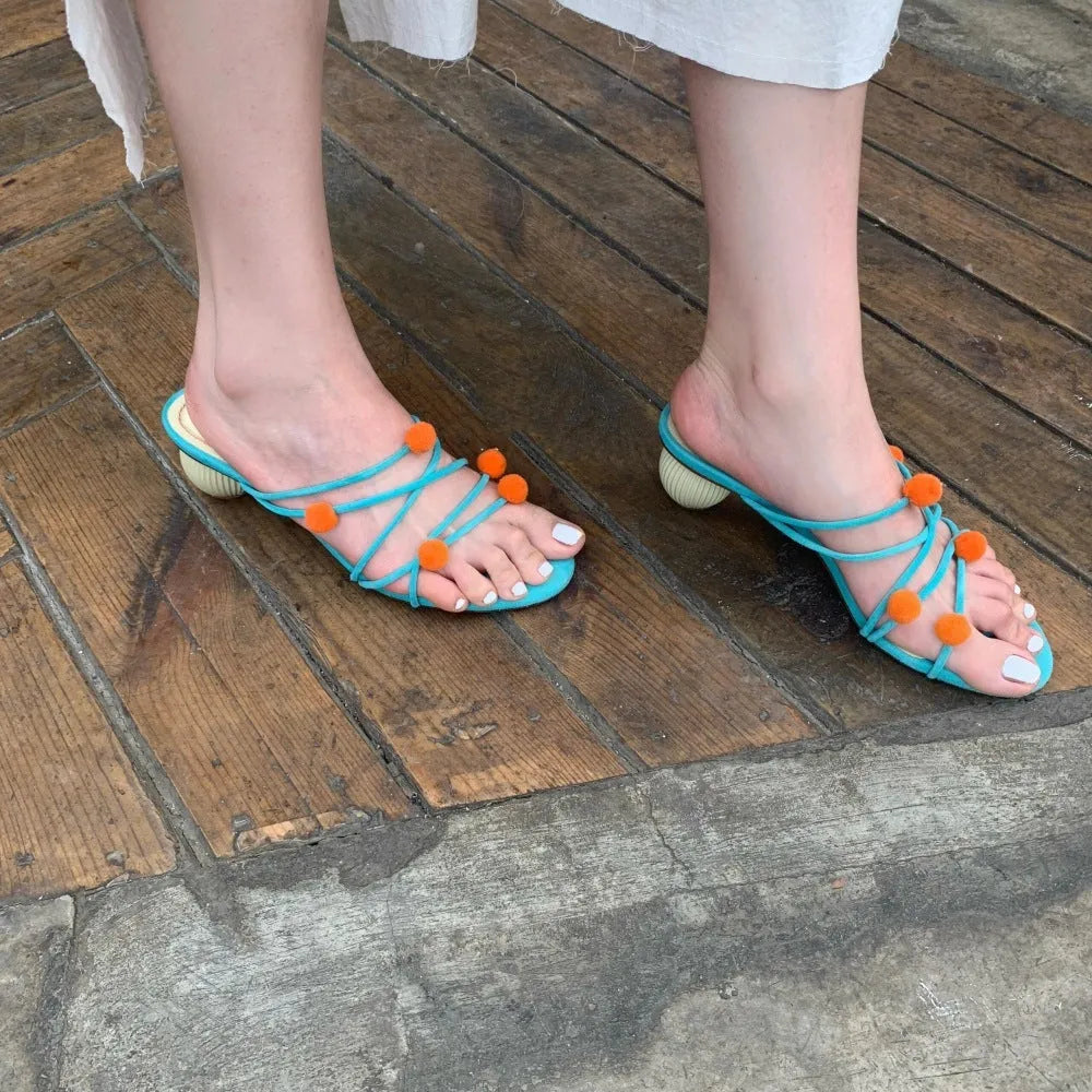 Cyan women's high-heeled sandals with lace-up ball detail and thin straps, open toe, on a rubber sole.