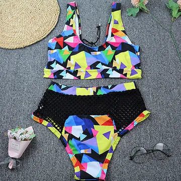 Women's multicolour checkered bikini set with cross-strap bra and high-waist fishnet briefs on a neutral background.