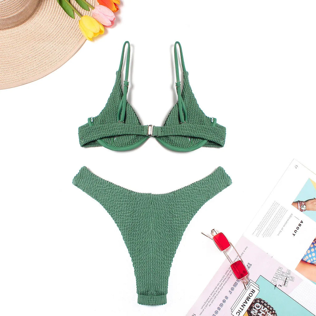 Women's solid green bikini suit with ruffle detailing and split-front design on mannequin