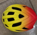 Orange mountain bike helmet showing ventilation holes and in-mould construction
