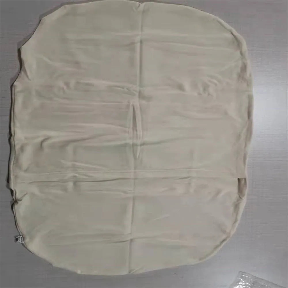 Cotton portable baby nest crib for newborns, beige colour, shown on a bed.