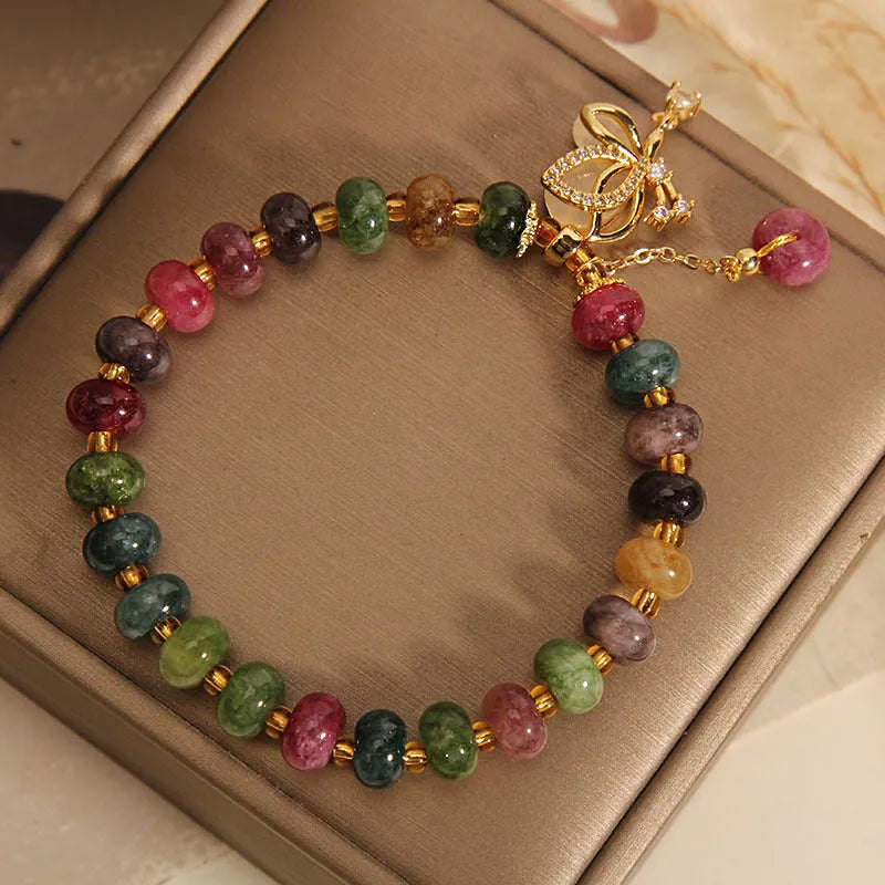 Colourful women's bracelet with a silver butterfly charm, colourful beads, and green tourmaline stones.