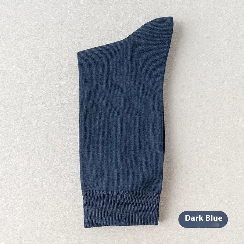 Five pairs of men's solid colour mid-calf socks made from combed cotton, shown in assorted shades.