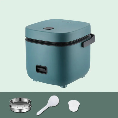 Green 1.2L mini rice cooker with metal body, steaming plate, rice spoon and measuring cup on countertop