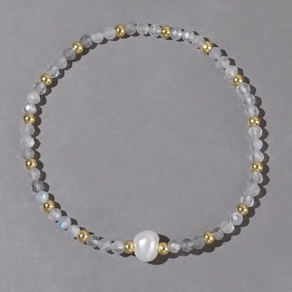 Close-up of a unisex natural stone bracelet with geometric ellipse beads on a wrist.