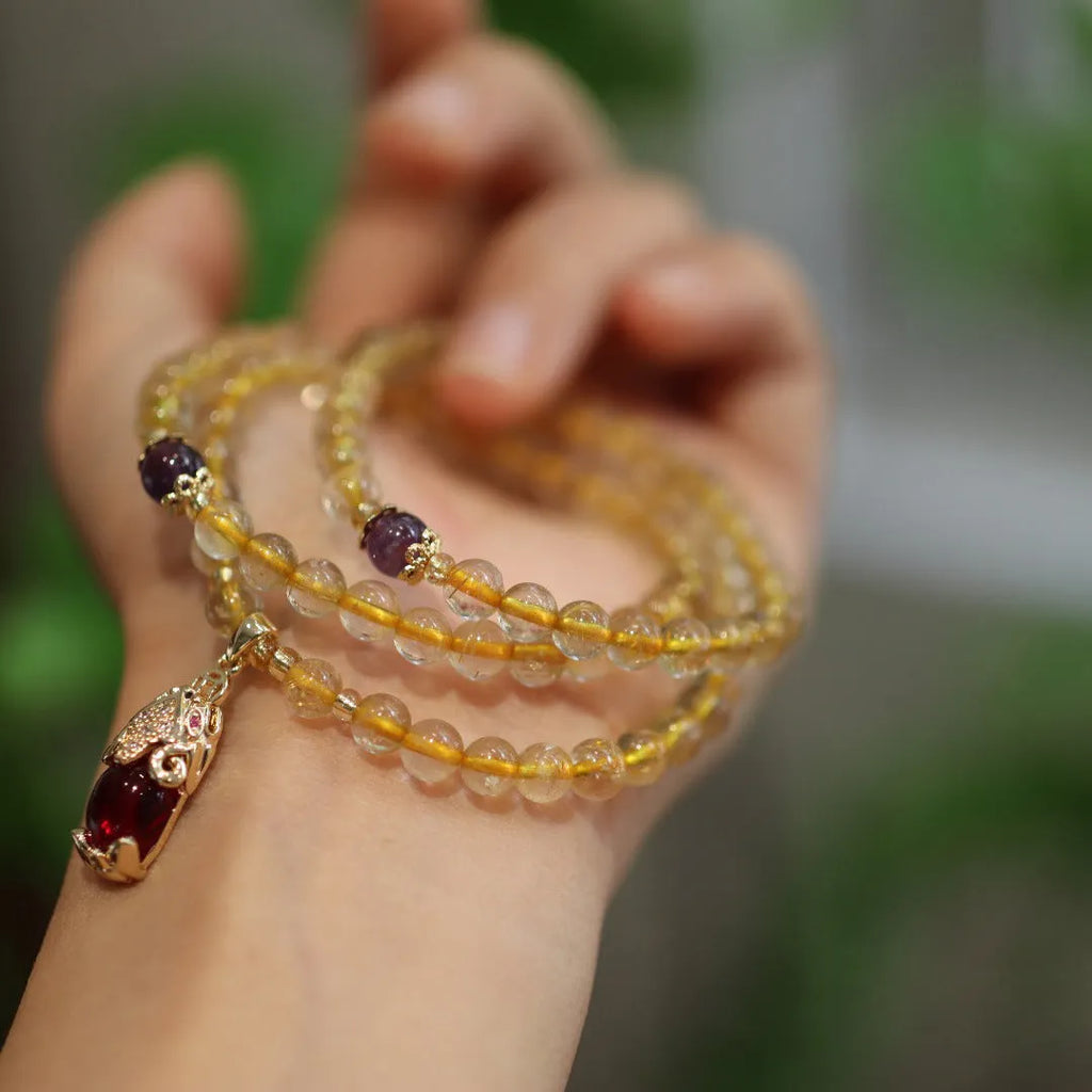 Natural gold rutilated quartz bracelet with three-circle gold and ruby bead design