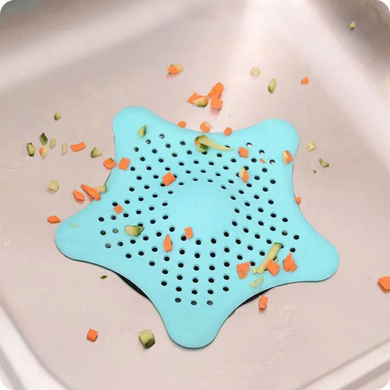 Three starfish-shaped TPR sink drain filters in blue, green, and white on a bathroom sink