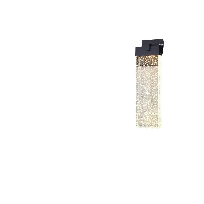Black stainless steel outdoor LED wall lamp mounted on a wall, showing its rectangular shape and warm light emission.