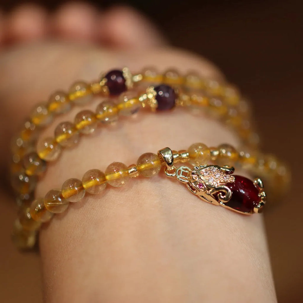 Natural gold rutilated quartz bracelet with three-circle gold and ruby bead design