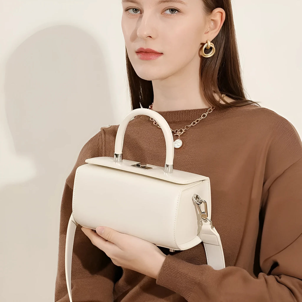Women's leather crossbody bag in clamshell design showing internal phone and file pockets.