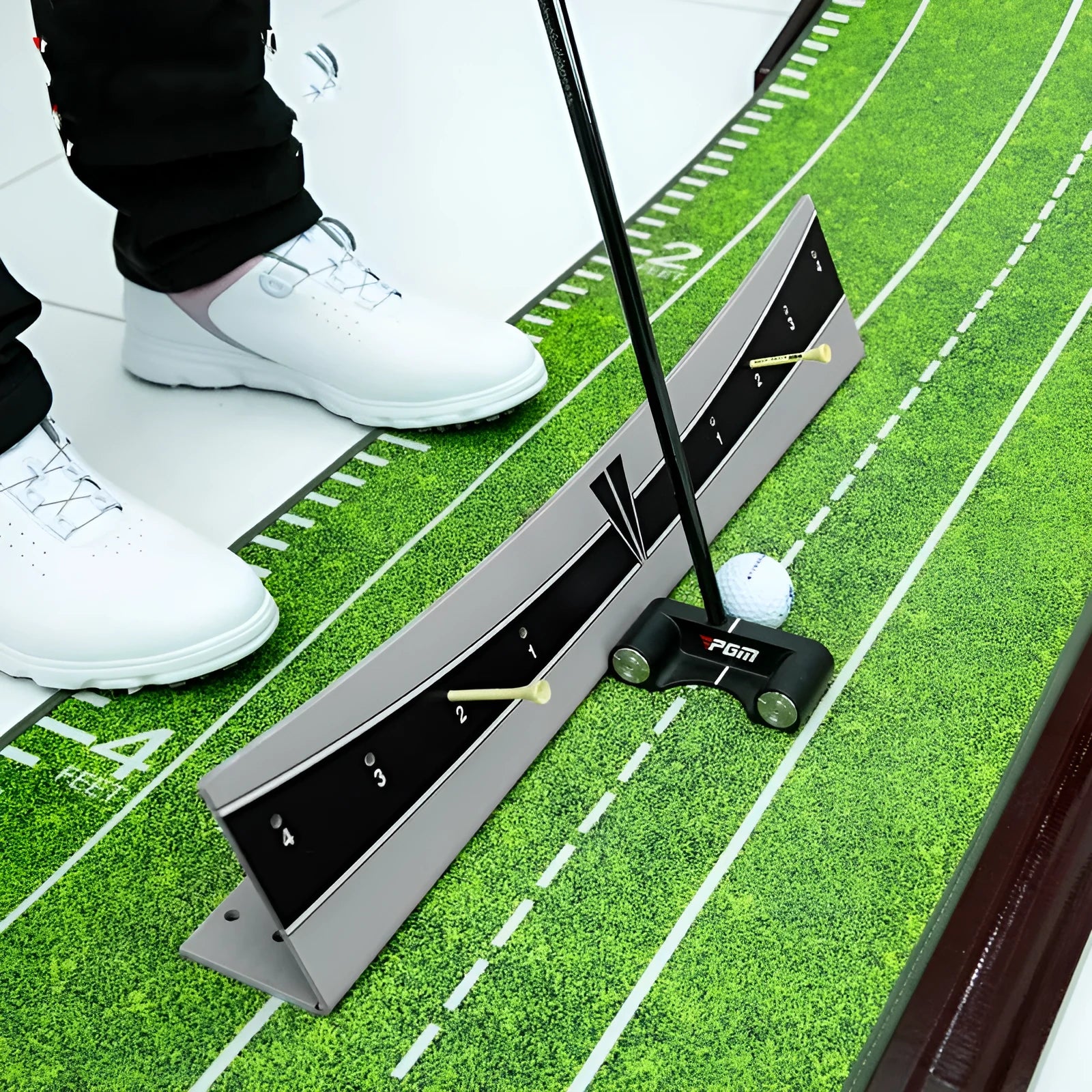 A white PVC golf putter trajectory balance simulator with an adjustable push rod balancer on a grey surface.