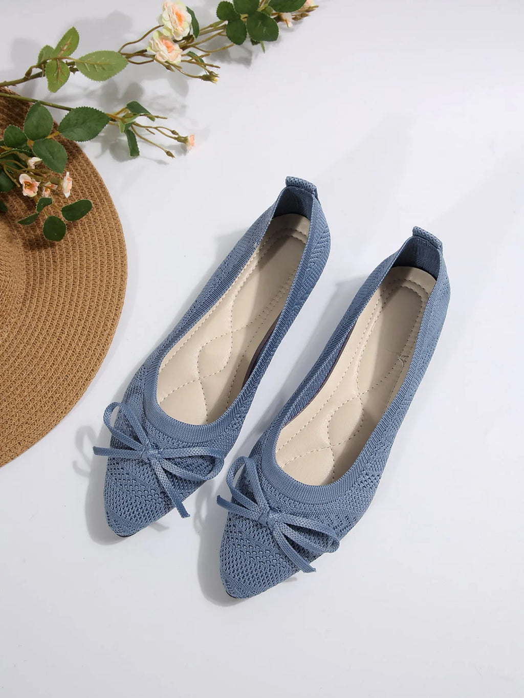 Women's blue knitted loafers with a bow and pointed toe on a flat rubber sole.