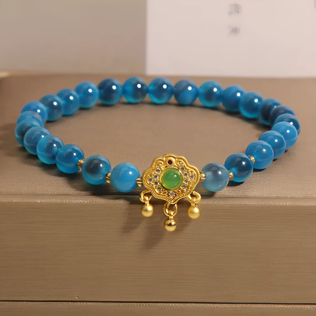 Blue sugar heart agate safety lock pendant on a women's crystal bracelet with rhinestone details.