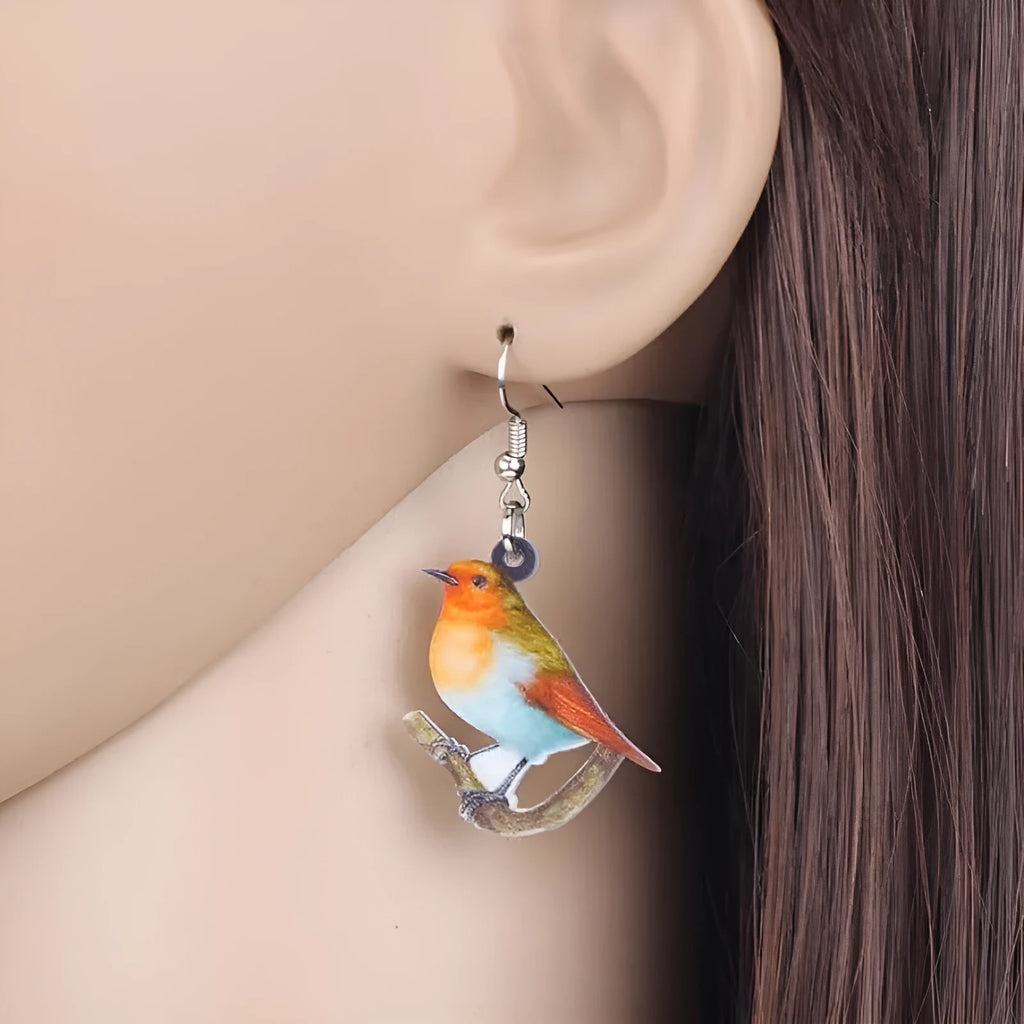 Acrylic clip-on earrings with a blue titmouse bird and geometric snake design.