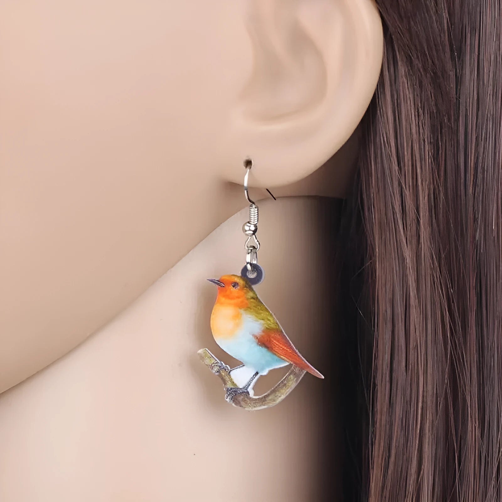 Acrylic clip-on earrings with a blue titmouse bird and geometric snake design.