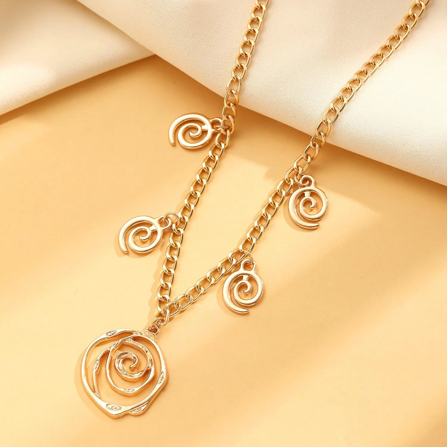 Spiral donut design jewellery set with necklace, bracelet and earrings in gold electroplated alloy