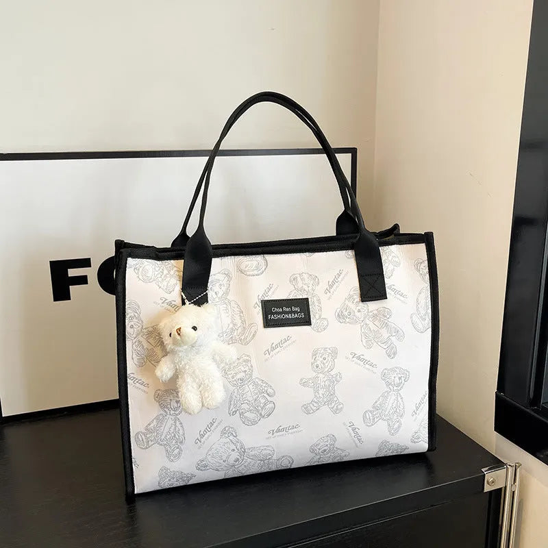 Women's black and white printed canvas tote bag with sandwich pocket and large capacity.