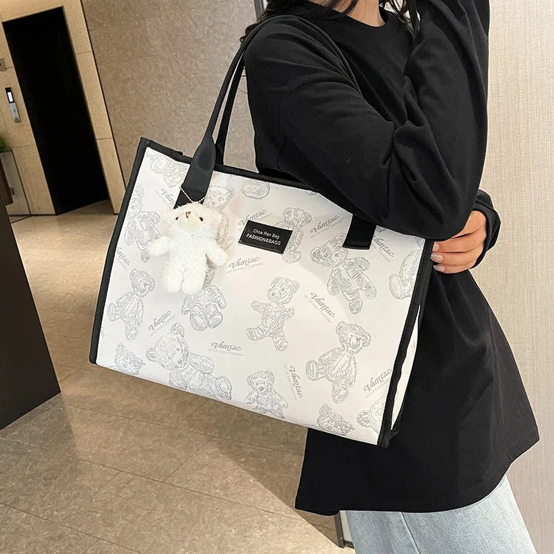 Women's black and white printed canvas tote bag with sandwich pocket and large capacity.