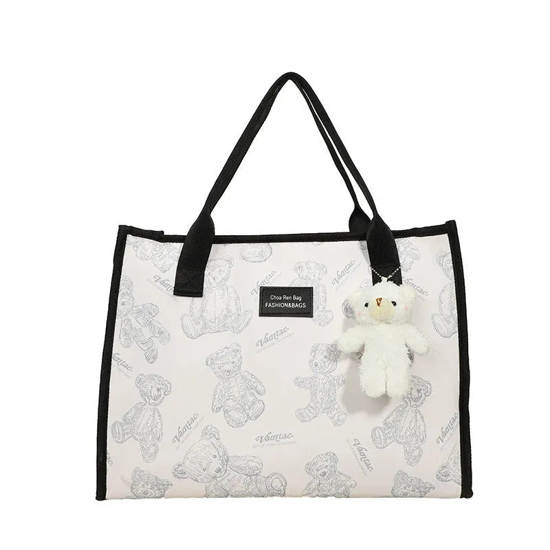 Women's black and white printed canvas tote bag with sandwich pocket and large capacity.
