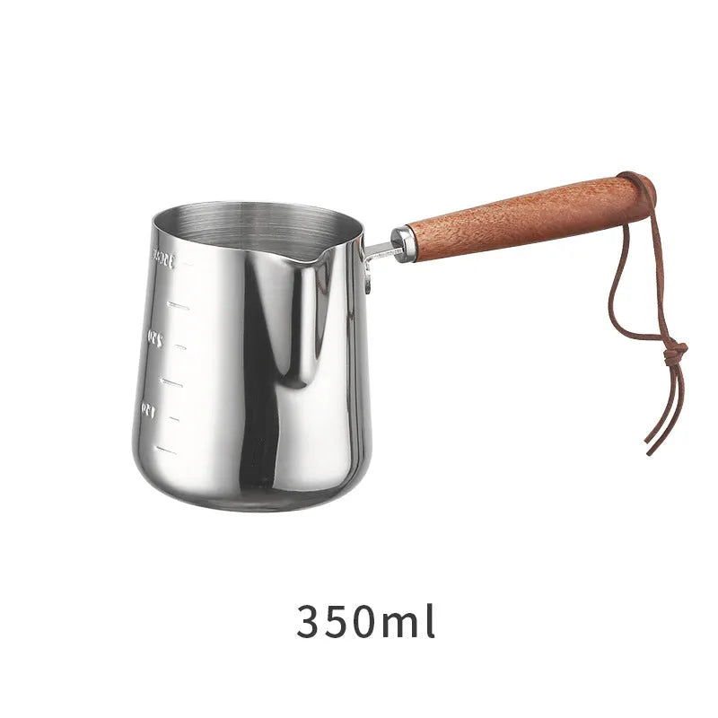 Stainless steel latte art milk cup with wooden handle and interior measuring scale