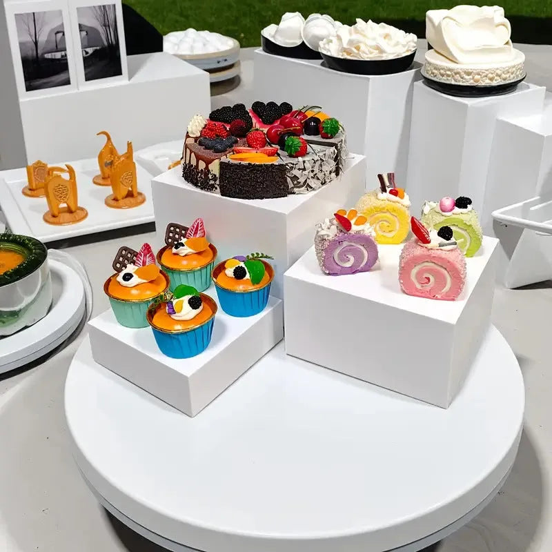 White plastic cube dessert display stand set of six pieces arranged on a table.