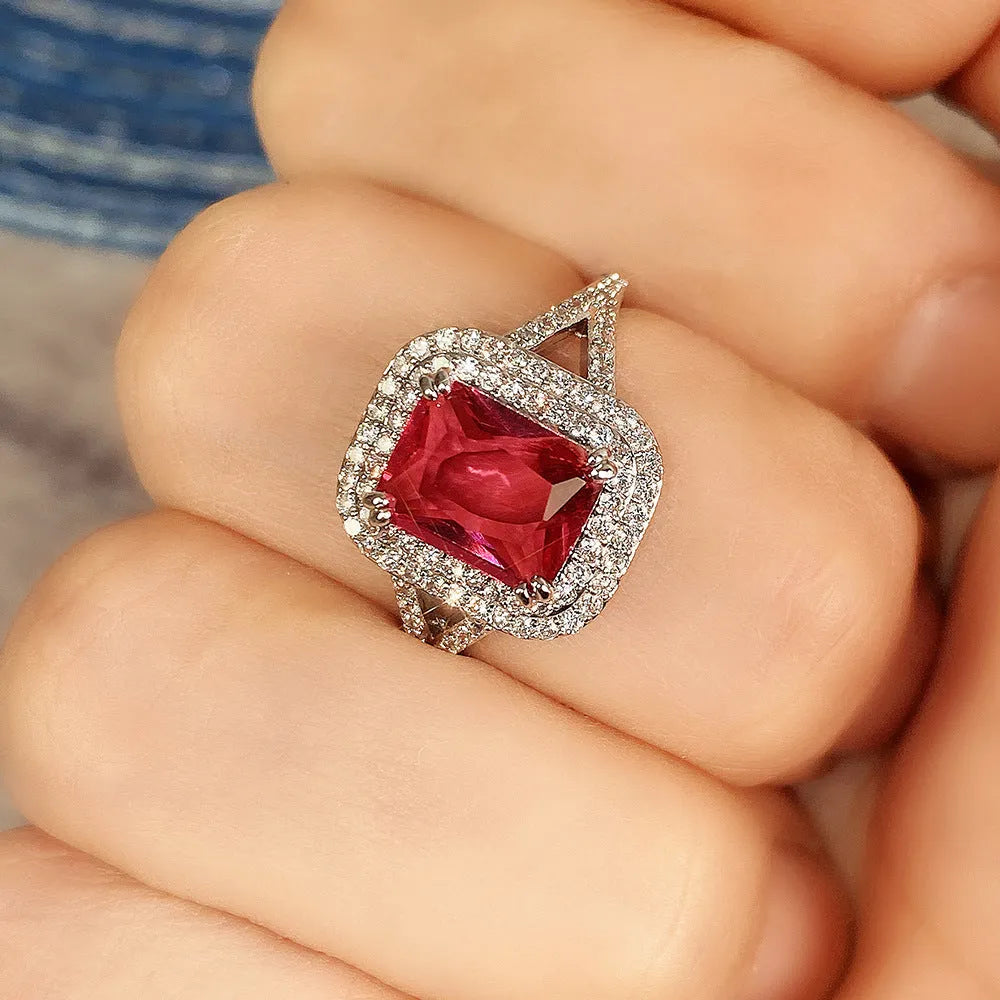 Women's copper square ring with a large red rhinestone centre on a hand.