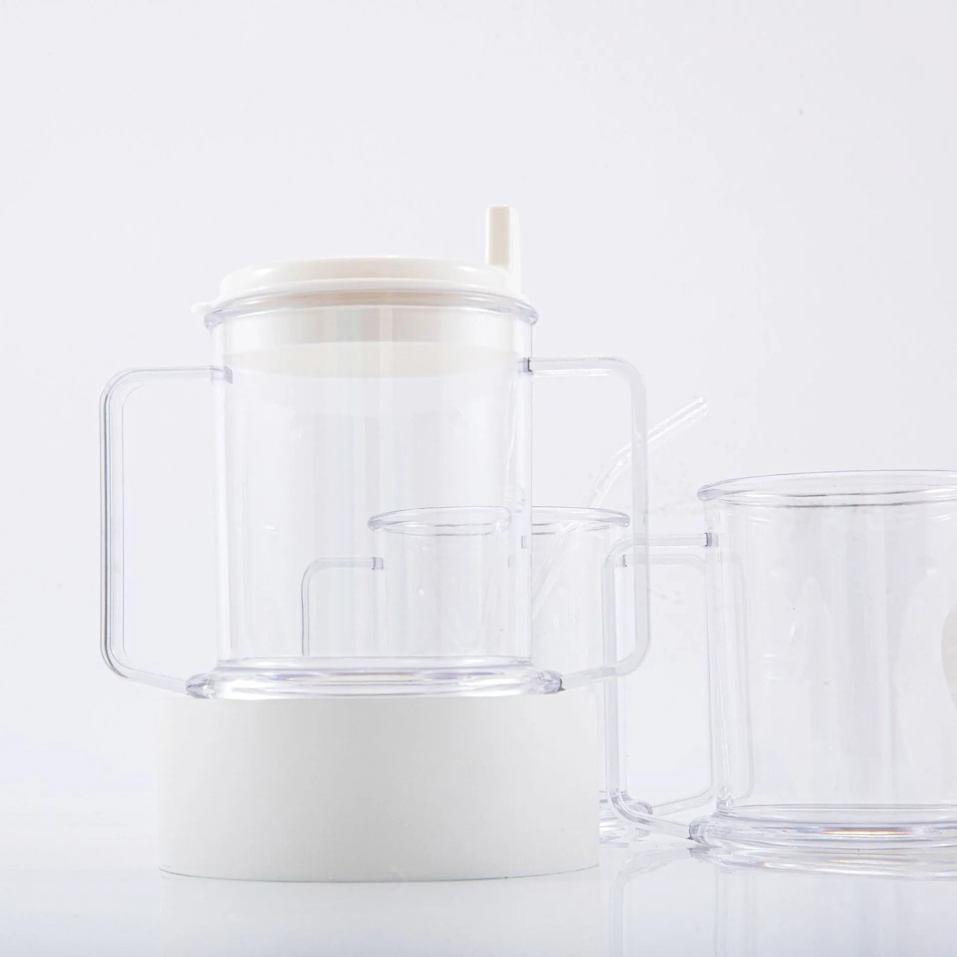 Transparent spill-proof plastic drinking cup with modern design on a plain background.