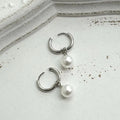 A pair of women's geometric alloy drop earrings with pearl finish and titanium steel posts.
