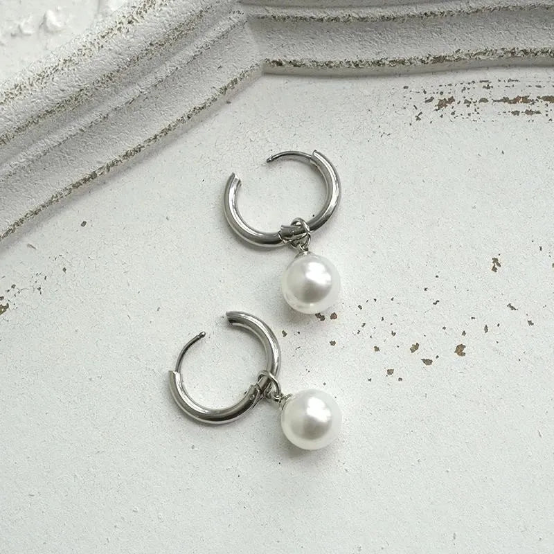 A pair of women's geometric alloy drop earrings with pearl finish and titanium steel posts.