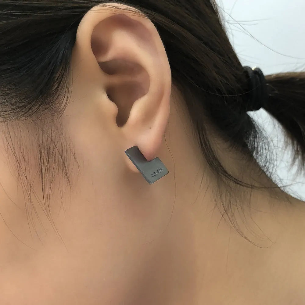 Oxidised black geometric square sterling silver earrings on a white background.
