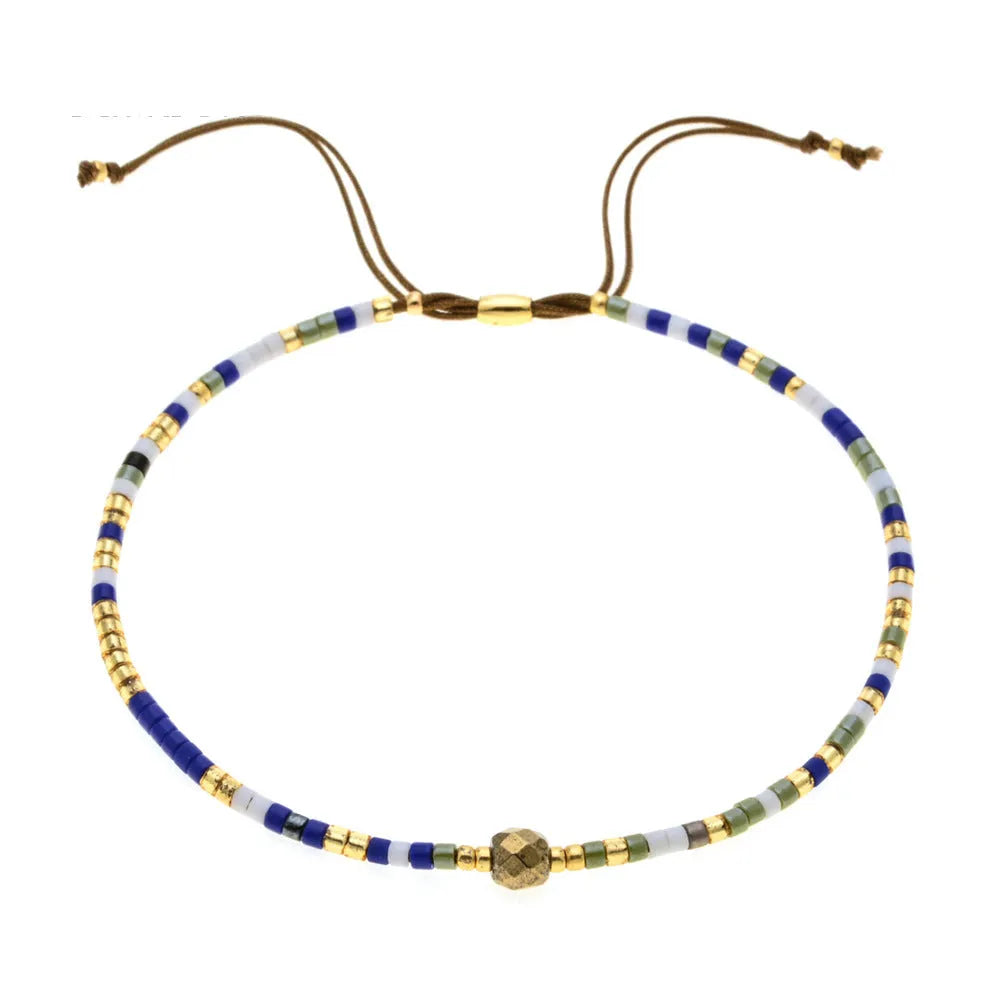 Close-up of a handmade women's bracelet with colourful glass and semi-precious stone geometric beads on a black stretch cord.