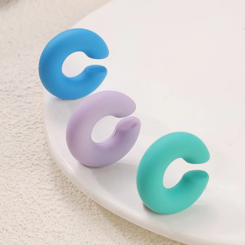 A pair of matte finish, coarse round C-shaped clip-on earrings for women in a choice of fifteen candy colours.