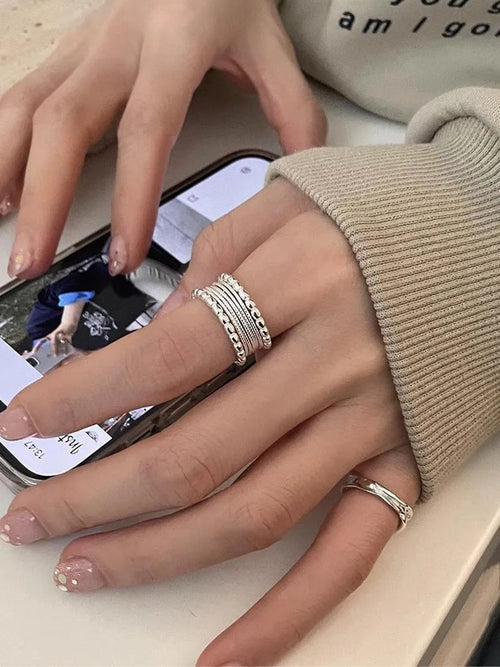 Copper-coloured geometric alloy ring with woven twisted texture and adjustable band.