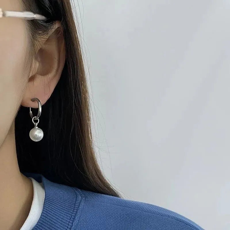 A pair of women's geometric alloy drop earrings with pearl finish and titanium steel posts.