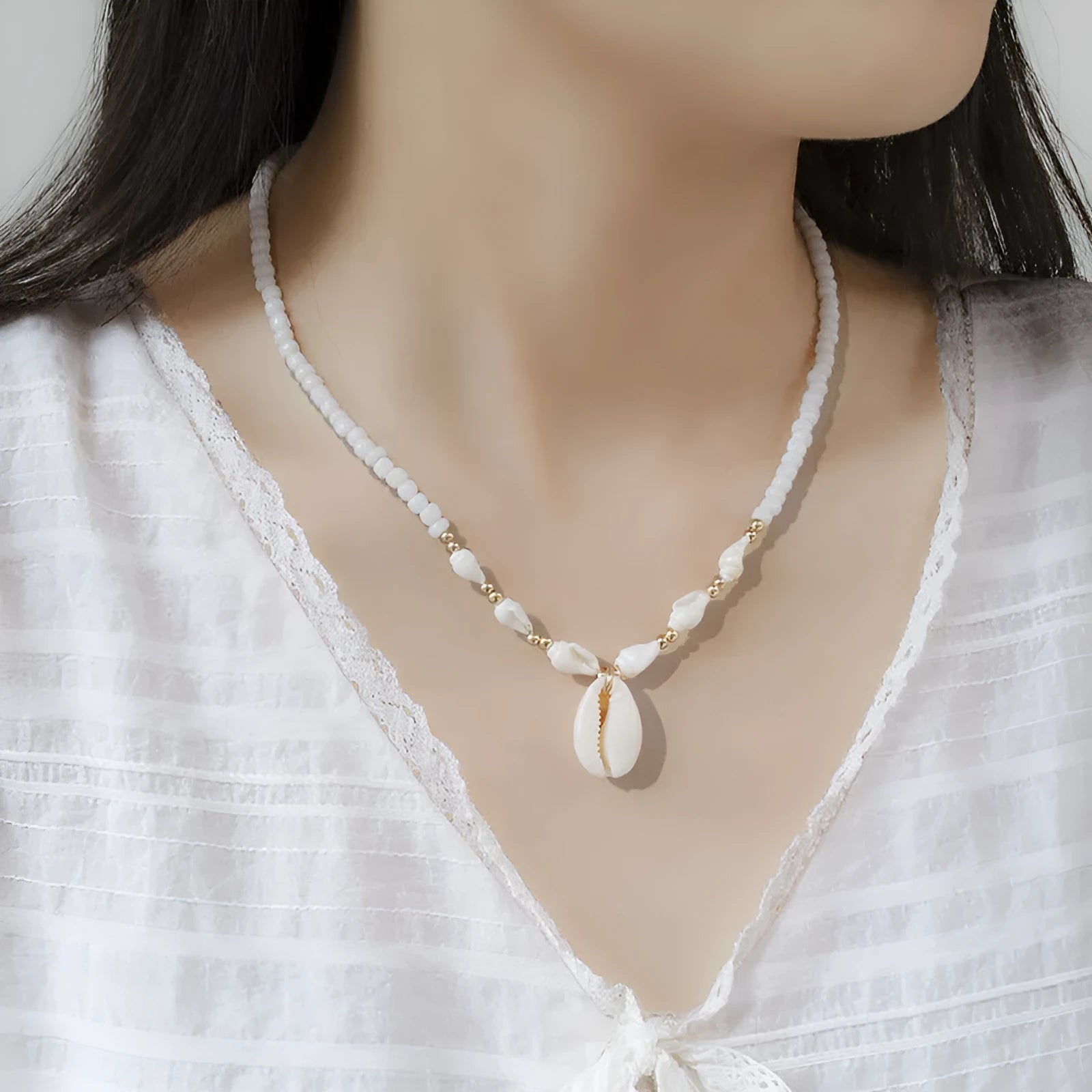 White bead necklace with a mother of pearl conch shell pendant on a regular chain.