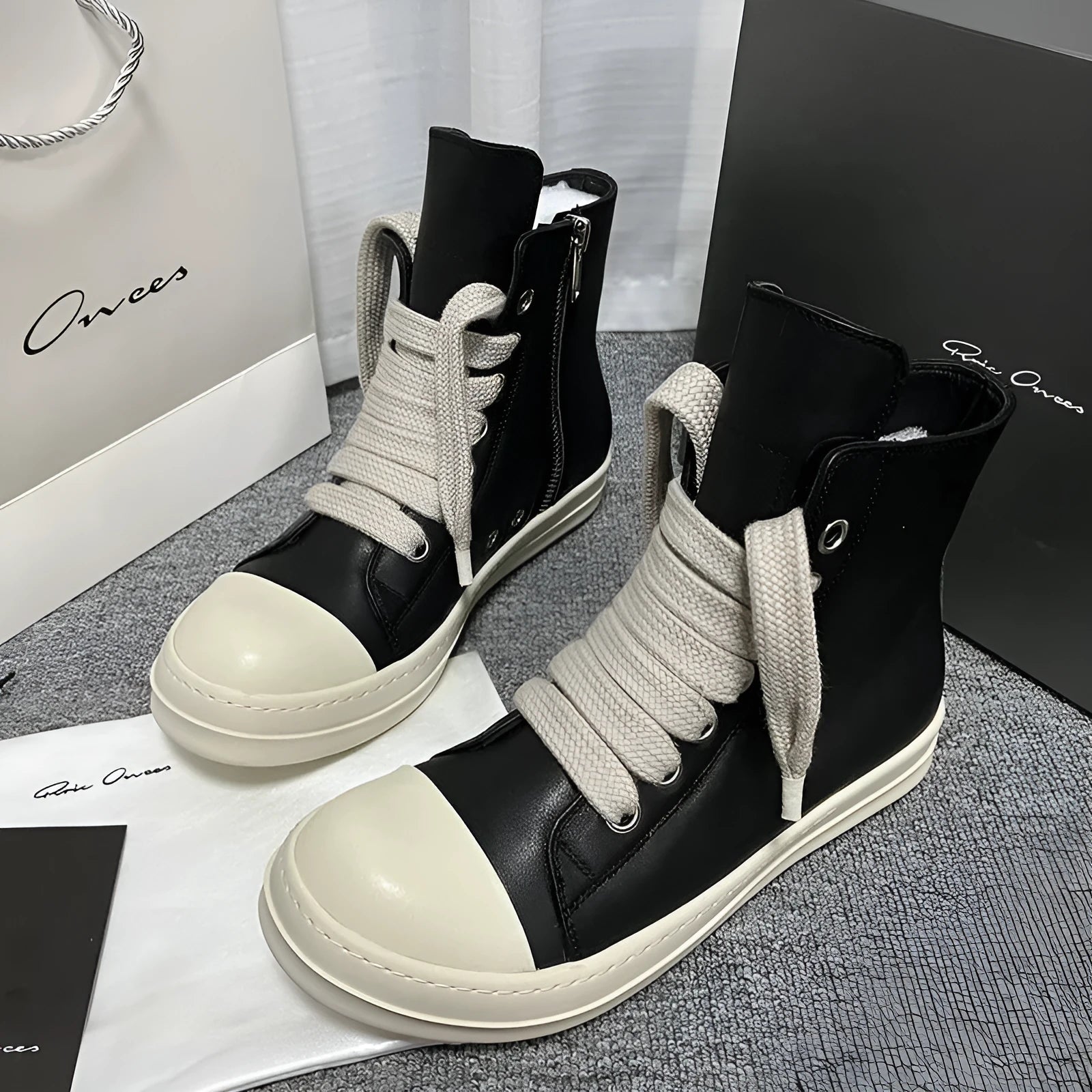 Black high-top leather sneakers with side zipper and round toe on a platform sole.