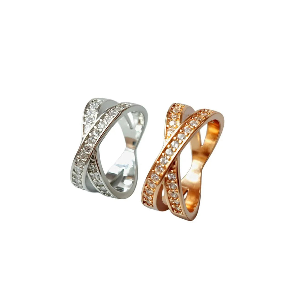 Metal ring with cross design and zircon detail in silver or rose gold finish.