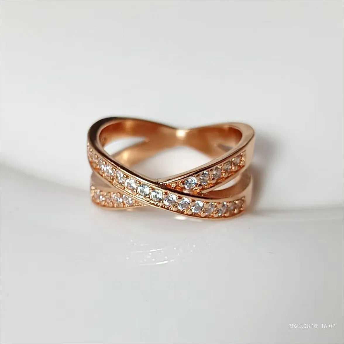 Metal ring with cross design and zircon detail in silver or rose gold finish.