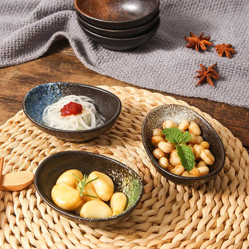 Oval-shaped Japanese ceramic sauce dipping bowl with an underglaze decorative pattern.
