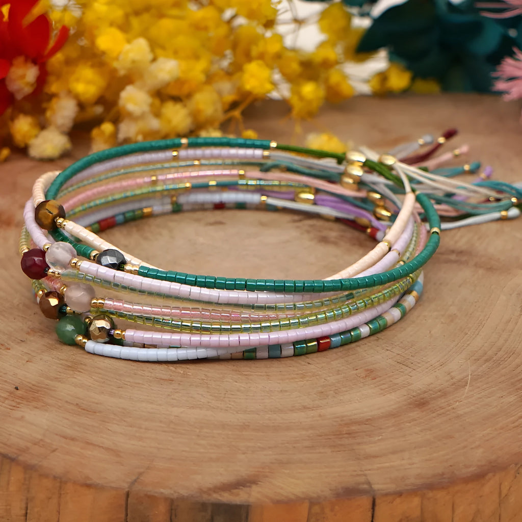 Close-up of a handmade women's bracelet with colourful glass and semi-precious stone geometric beads on a black stretch cord.