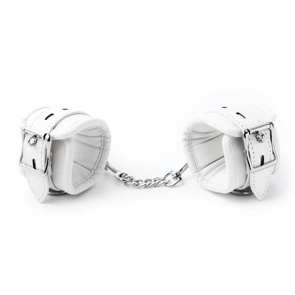 White PU sponge bondage sex toy set showing handcuffs, foot cuffs, and a neck scarf laid out.