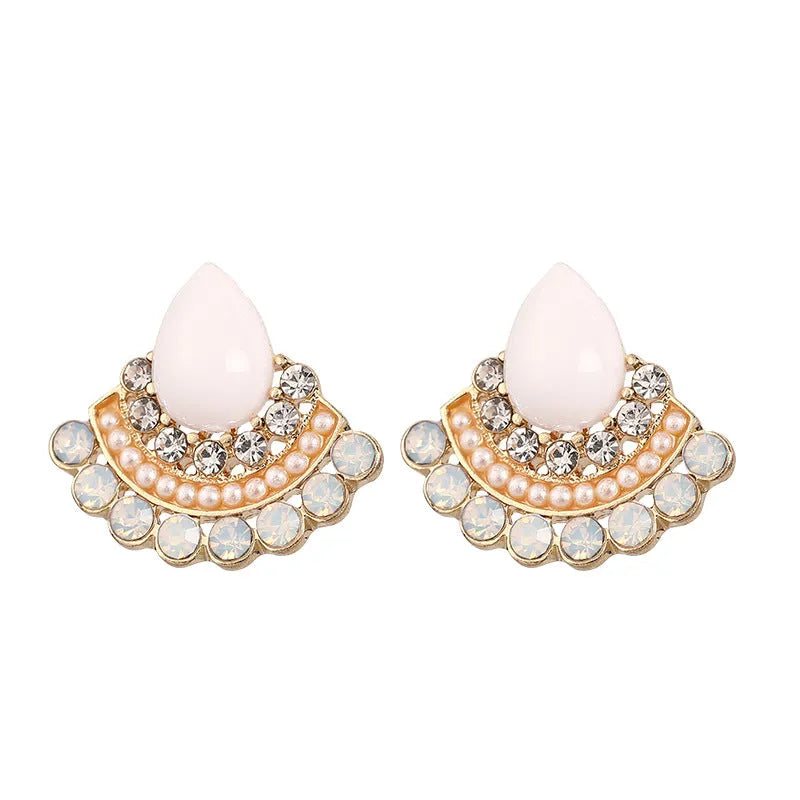 Silver retro fan-shaped stud earrings with rhinestone and opal details on a grey background.